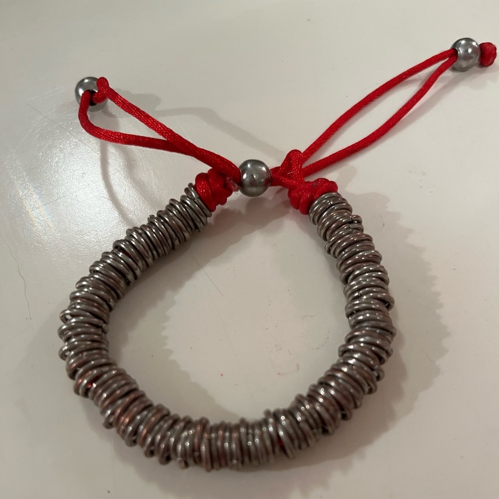 Silver coloured links on red string